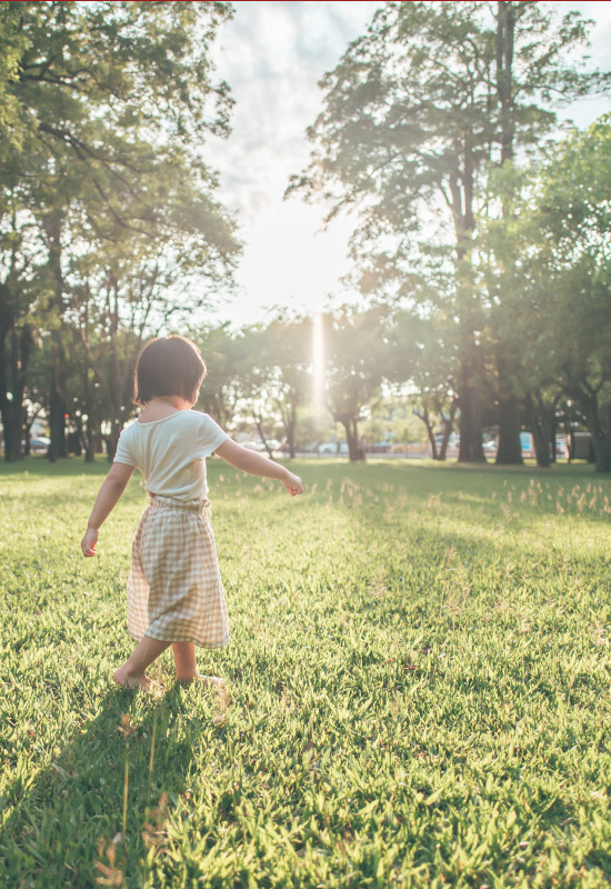 child with autism walking on grass in sun